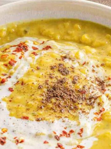 Image shows a bowl of Vegan Yellow Dentil Dal with a spoon.