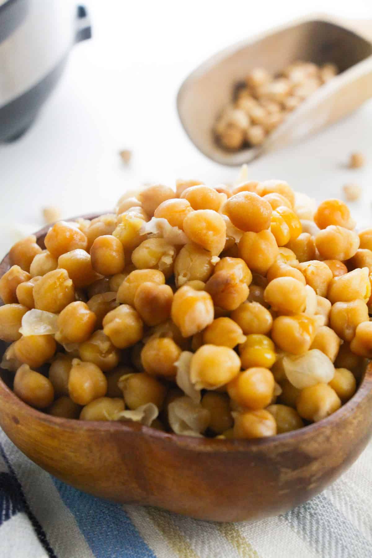 Close-up of cooked chickpeas in a wooden bowl.