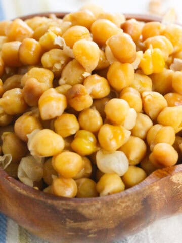 Close-up of cooked Instant Pot chickpeas in a brown wooden bowl.