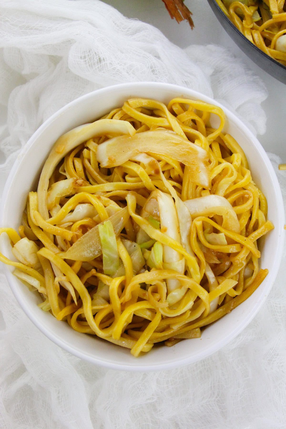 Close-up of easy cabbage chow mein served in a white bowl.