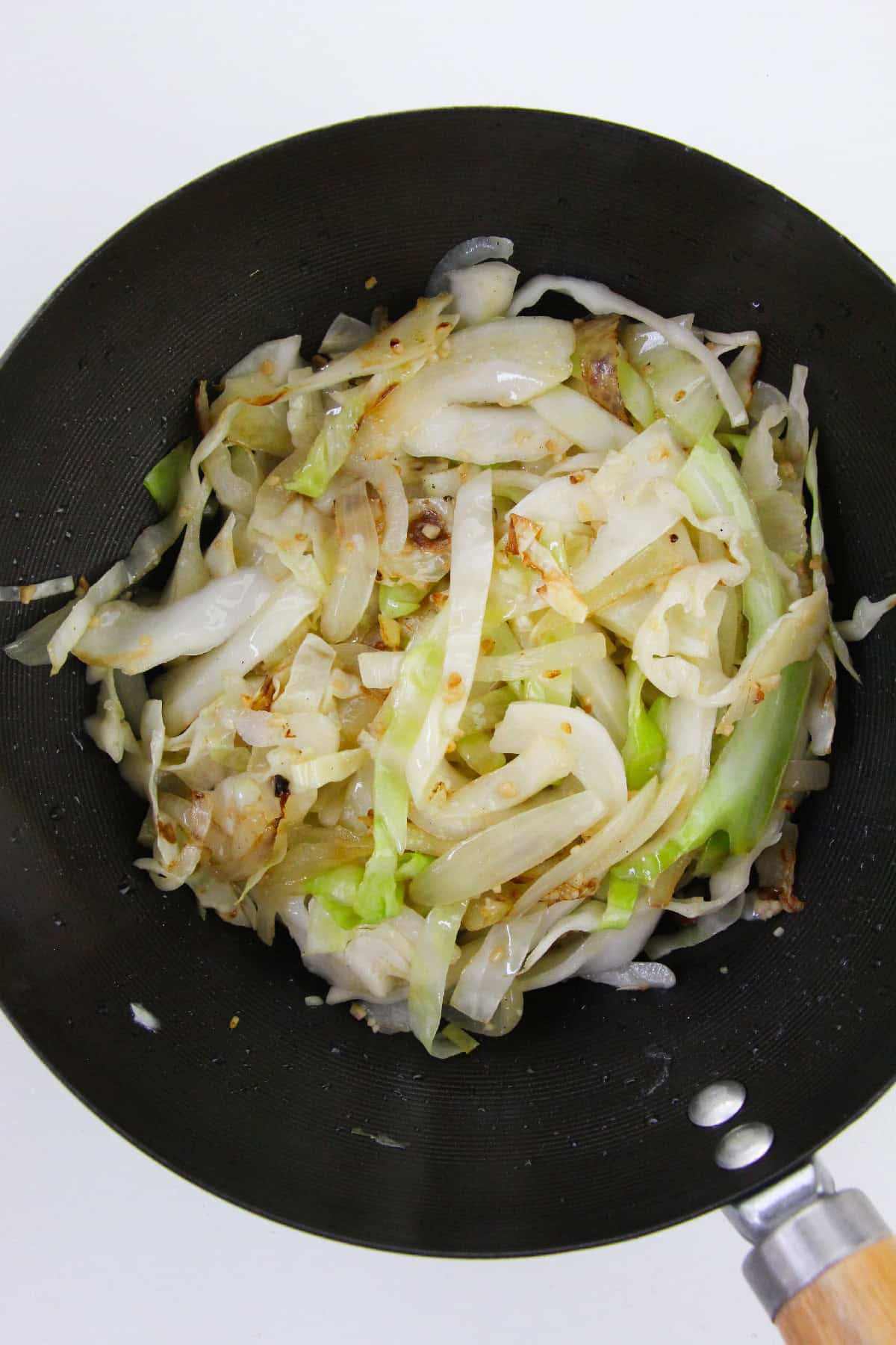 Cabbage and onions saut&eacute;ed until slightly browned in a wok.
