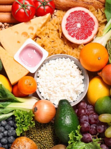 A colorful assortment of fruits, vegetables, dairy, grains, and proteins representing the components of a balanced diet.