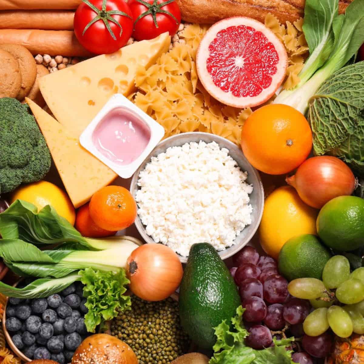 A colorful assortment of fruits, vegetables, dairy, grains, and proteins representing the components of a balanced diet.