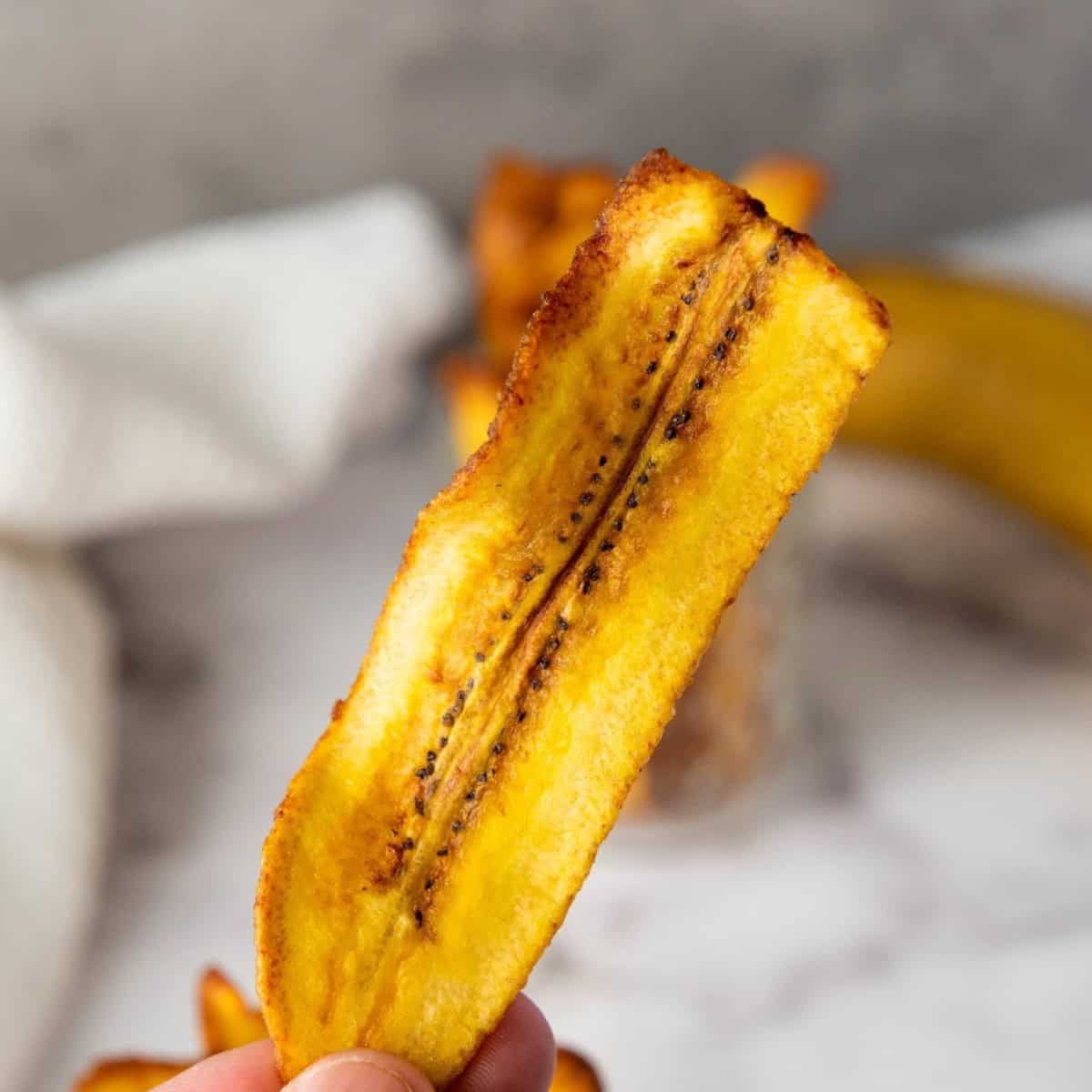 Close-up of a crispy chifles plantain chip showing golden texture.