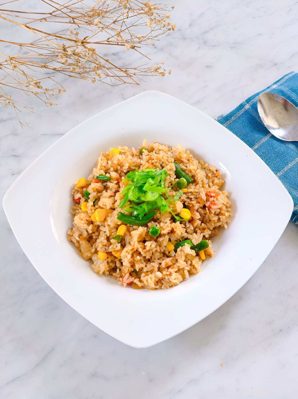Homemade frozen vegetable fried rice with corn, peas, and green beans in a white bowl.