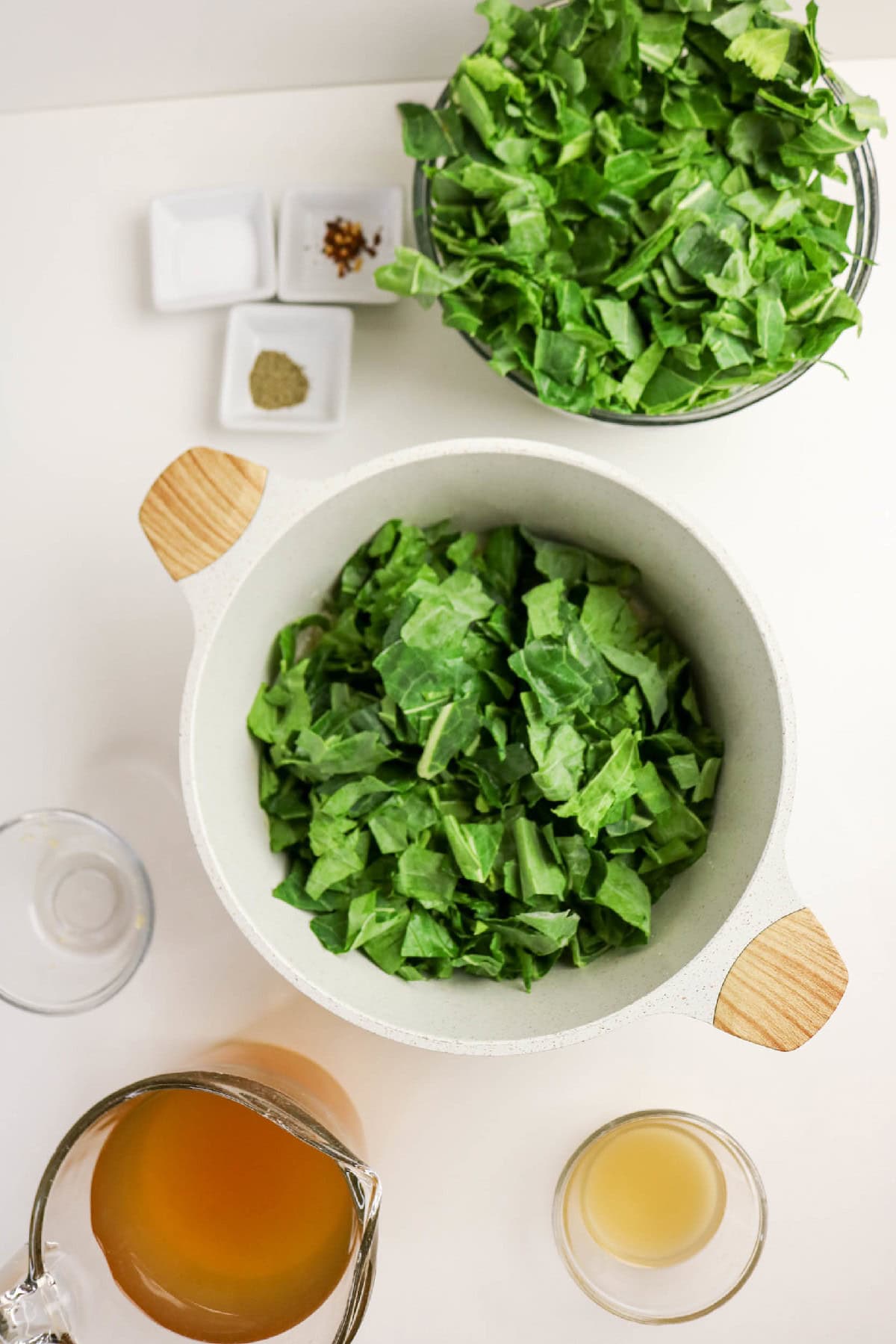 Fresh collard greens added to the pot for braising.
