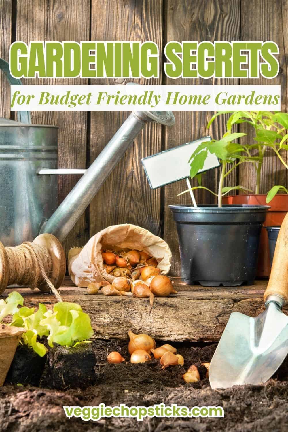 Garden tools, young plants, and onion bulbs laid out on soil against a weathered wooden fence.