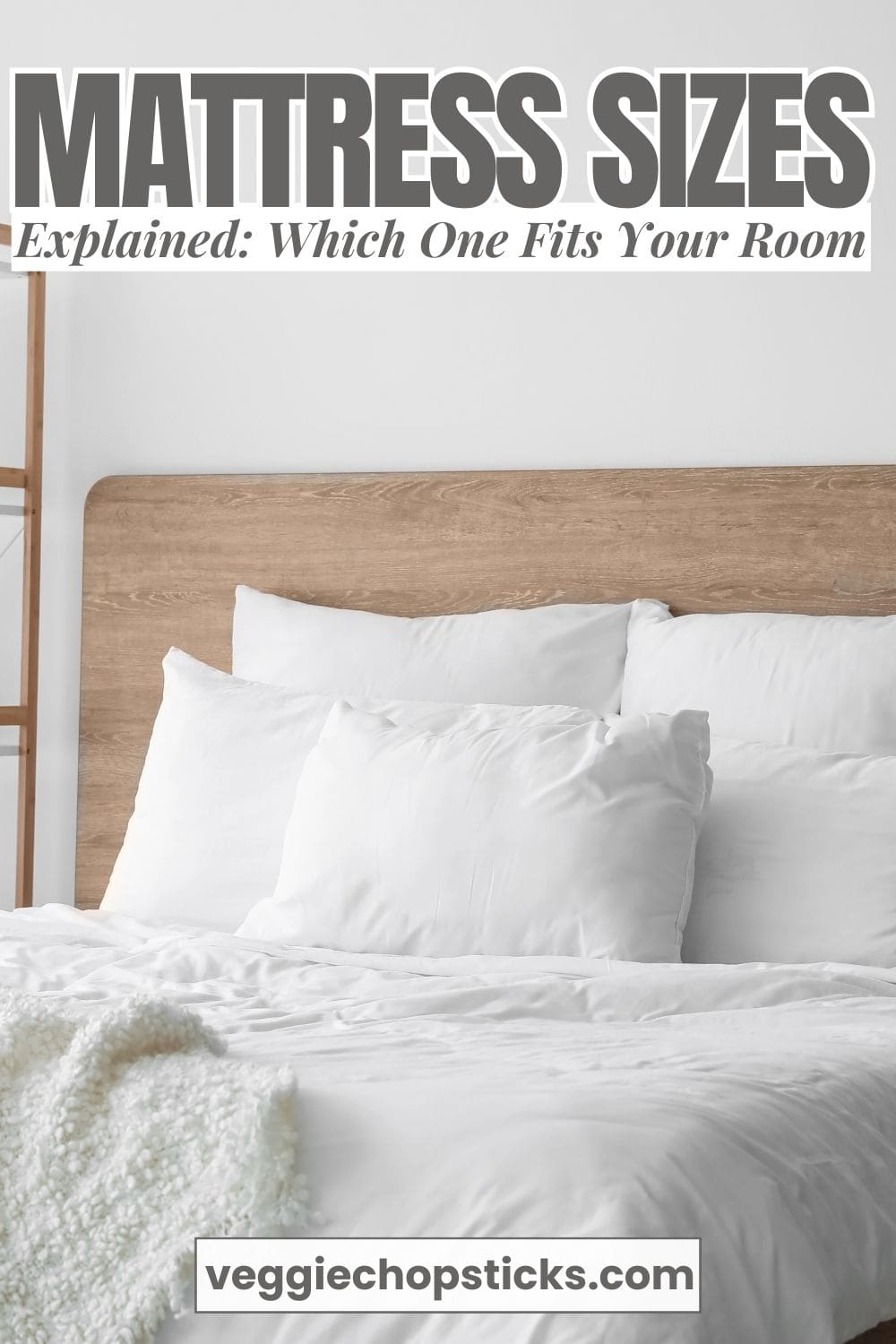 Clean, modern bedroom featuring a wooden bed frame, white linens, and soft neutral accents.