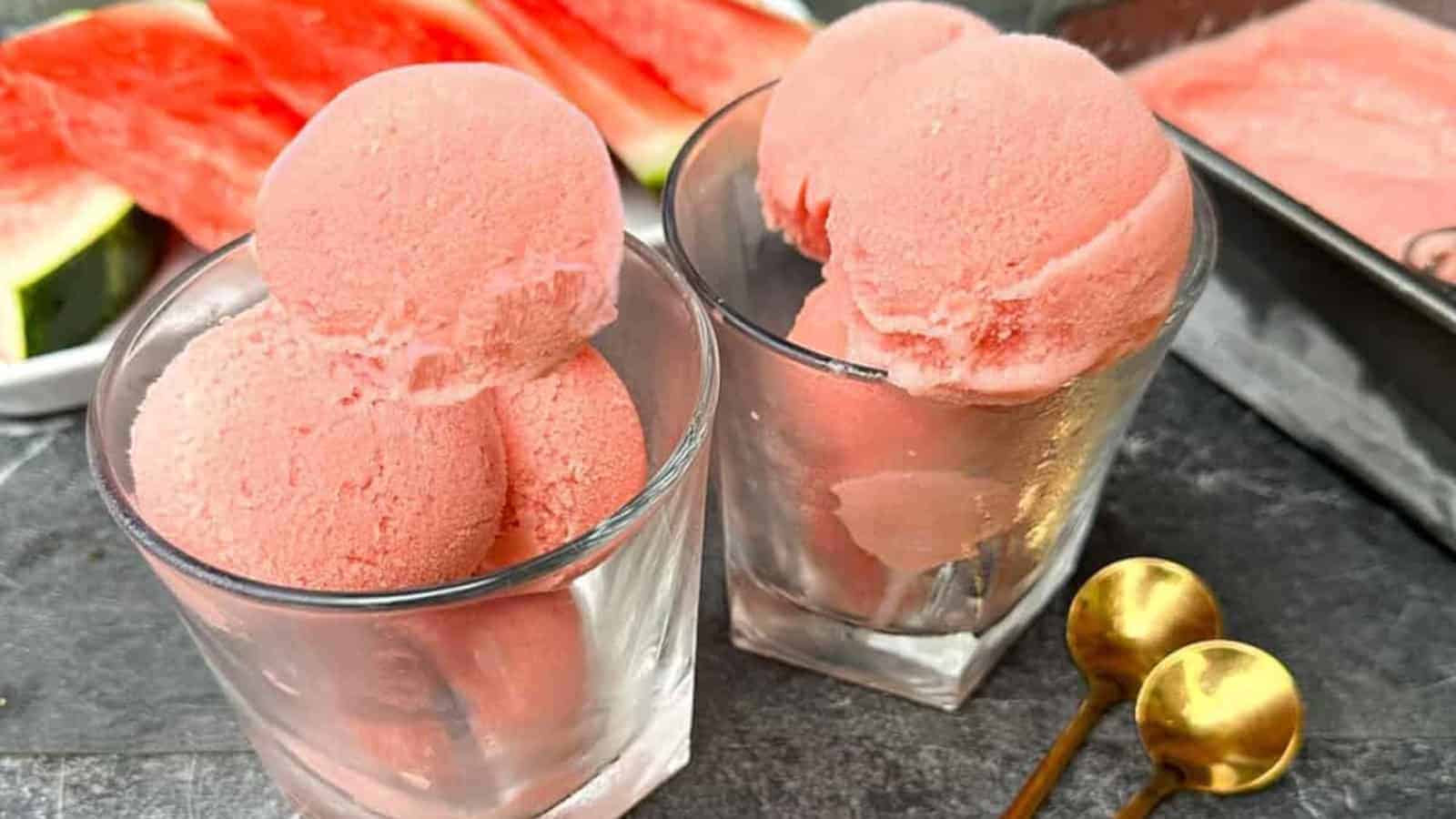 Two serving of watermelon ice cream in cups.