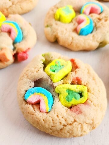 Lucky Charms cookies with colorful marshmallow pieces on a white plate.