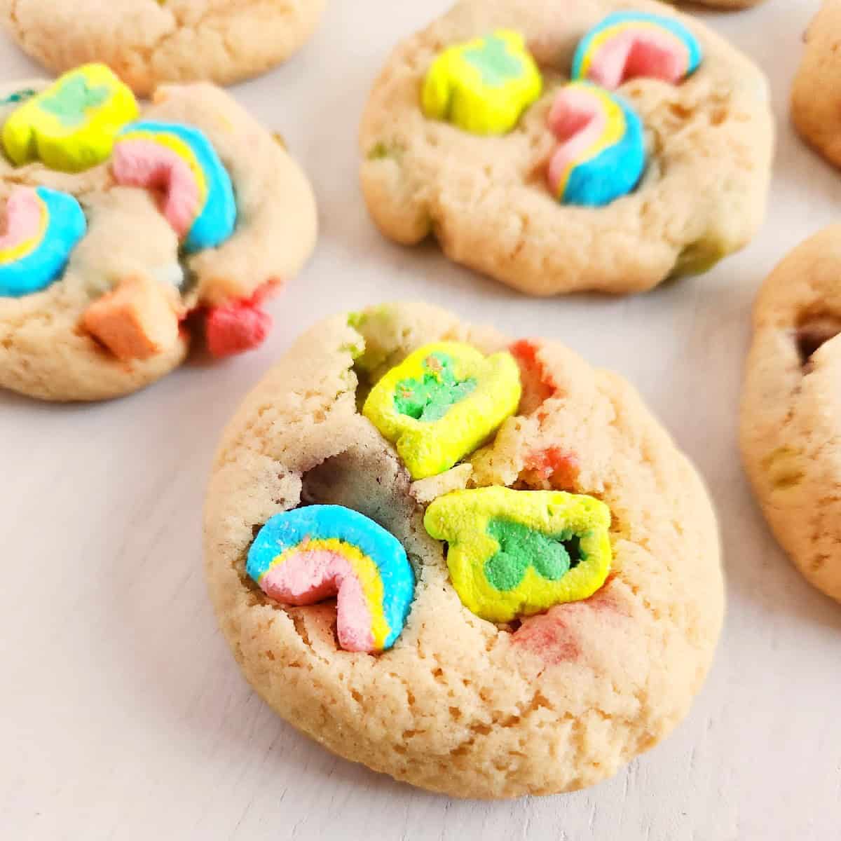 Lucky Charms cookies with colorful marshmallow pieces on a white plate.