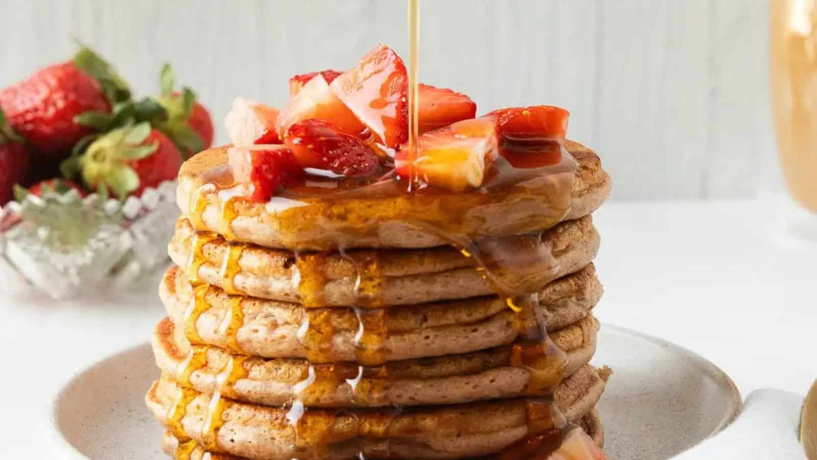 Strawberry pancakes stacked fluffy and topped with fresh berries.