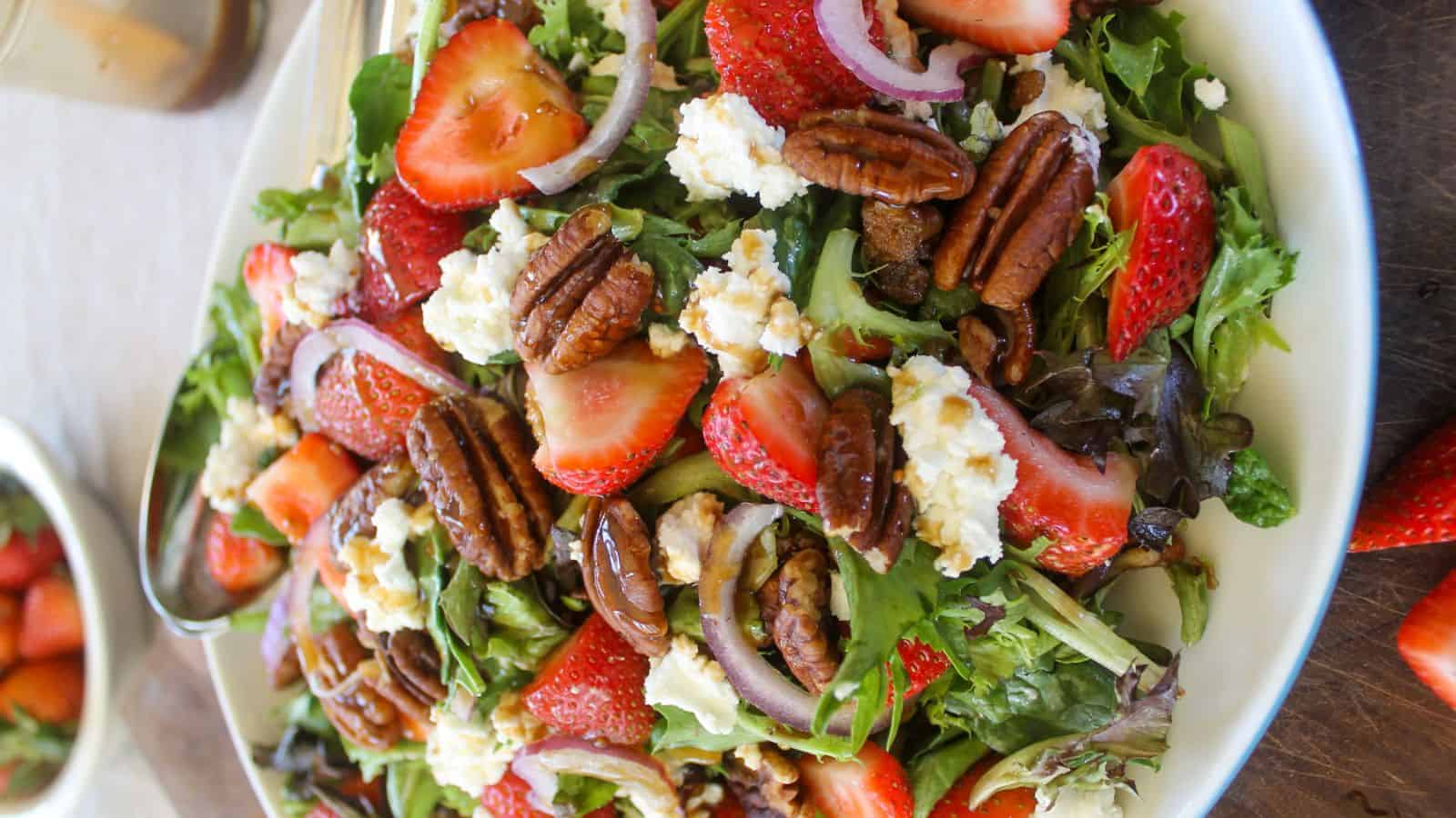 Strawberry goat cheese salad with fresh greens, berries, and creamy cheese crumbles.