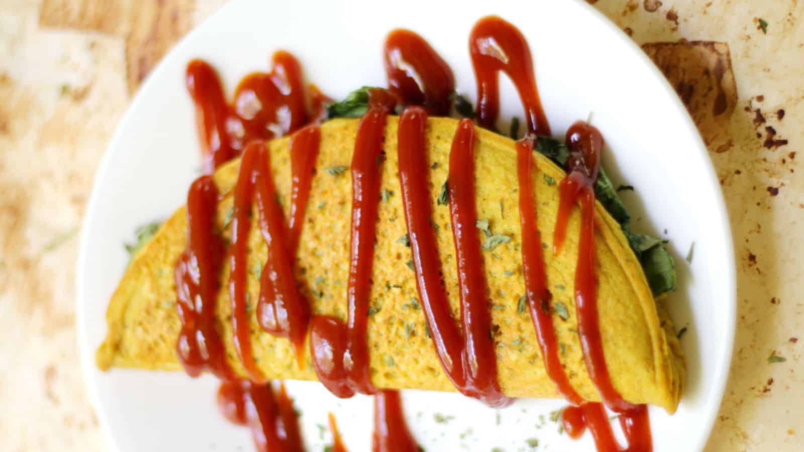 Vegan chickpea flour omelet filled with vegetables and cooked until lightly golden.