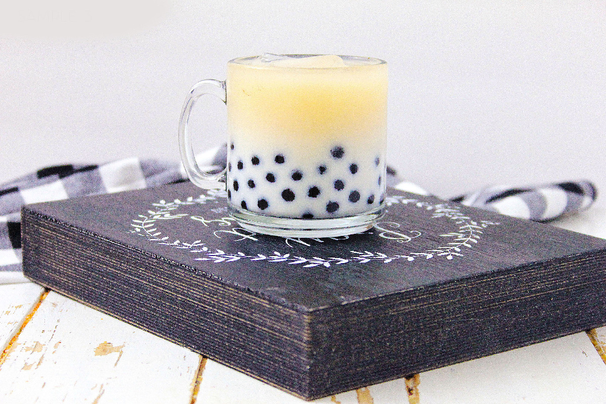 Homemade milk tea with boba pearls on a rustic serving board.