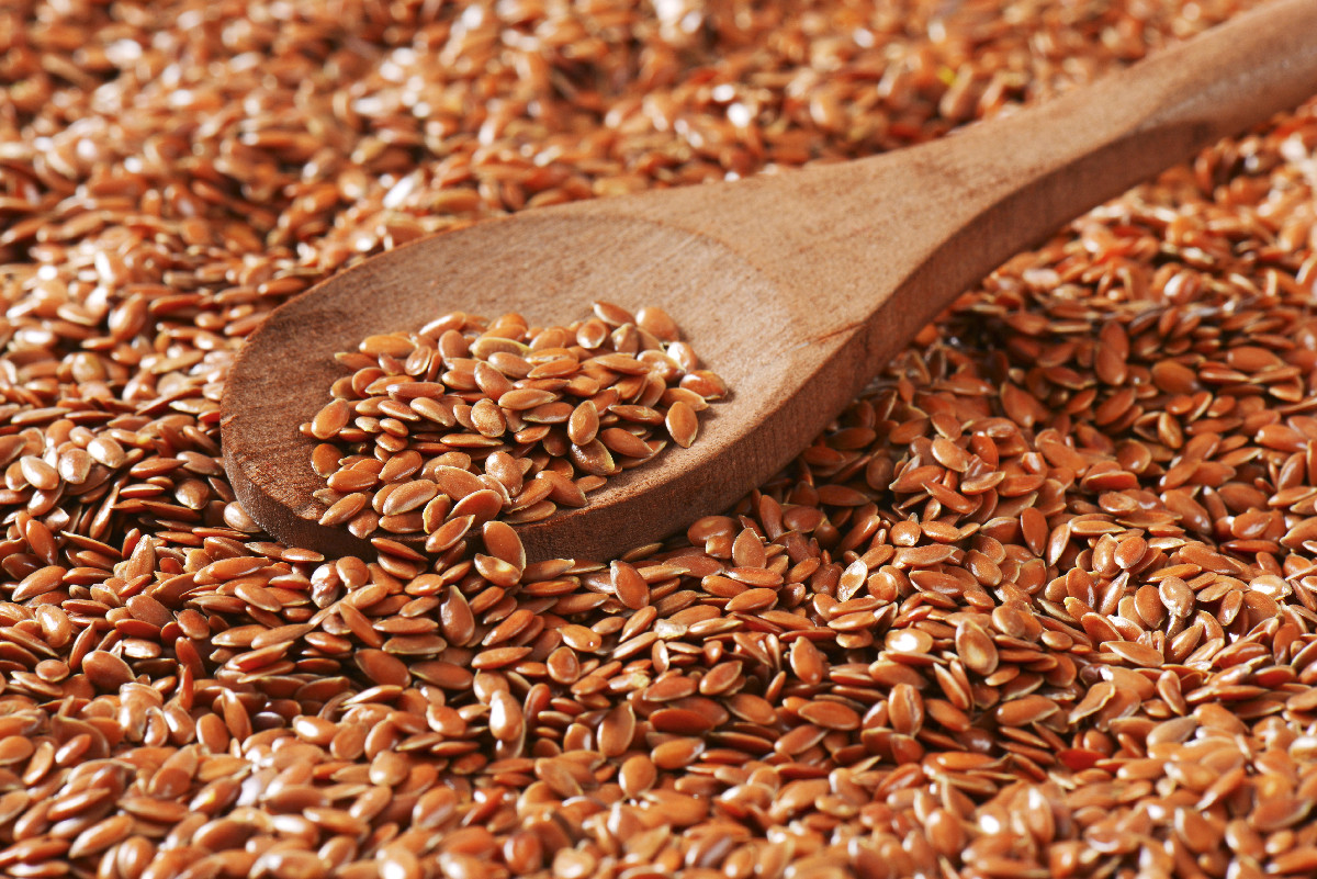 Flax seeds in a wooden spoon, rich in omega-3 fatty acids and plant-based healthy fats.
