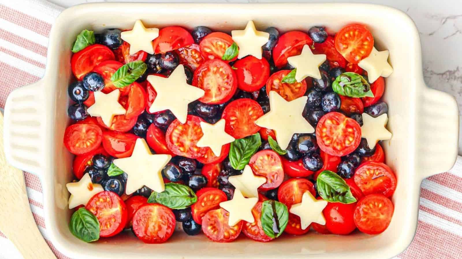 Berry caprese salad layered with fruit, cheese, and fresh herbs.