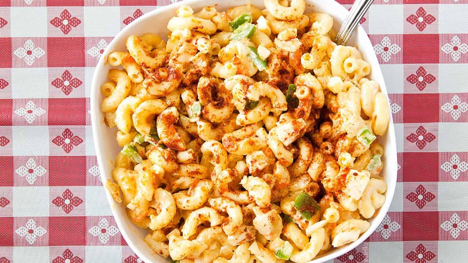 Macaroni salad mixed with creamy dressing and vegetables.