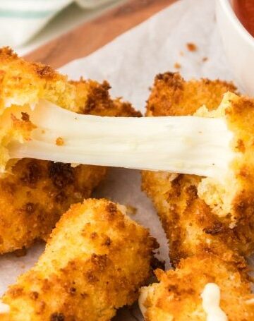Crispy veggie chicken bites with melty cheese and dipping sauce on a white plate.