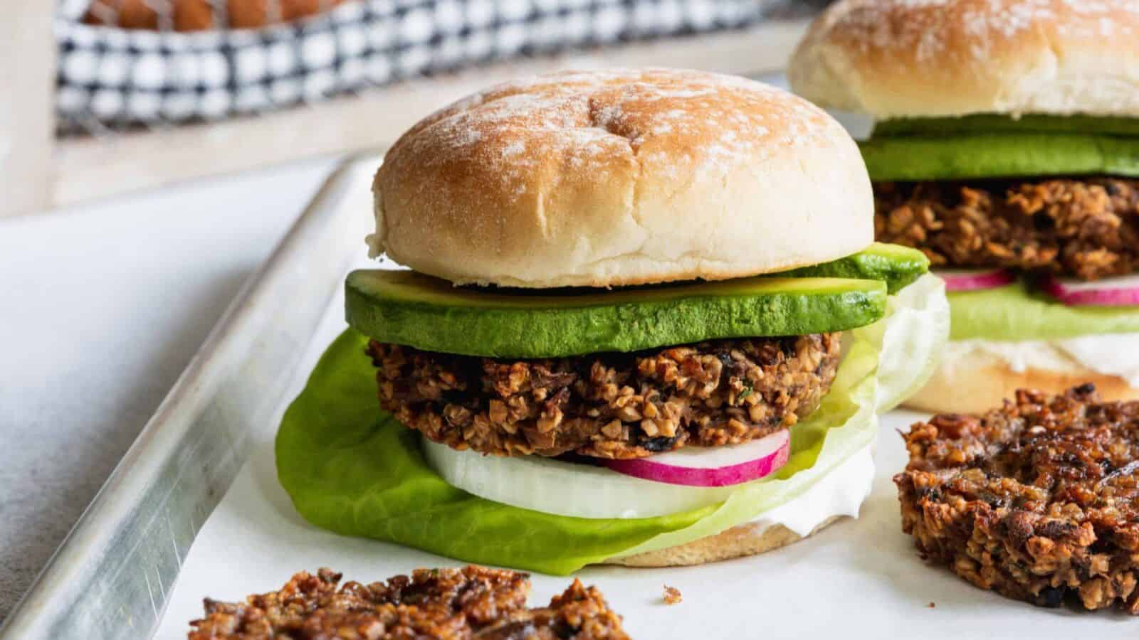 Mushroom oat burgers stacked on buns with fresh toppings and hearty texture.
