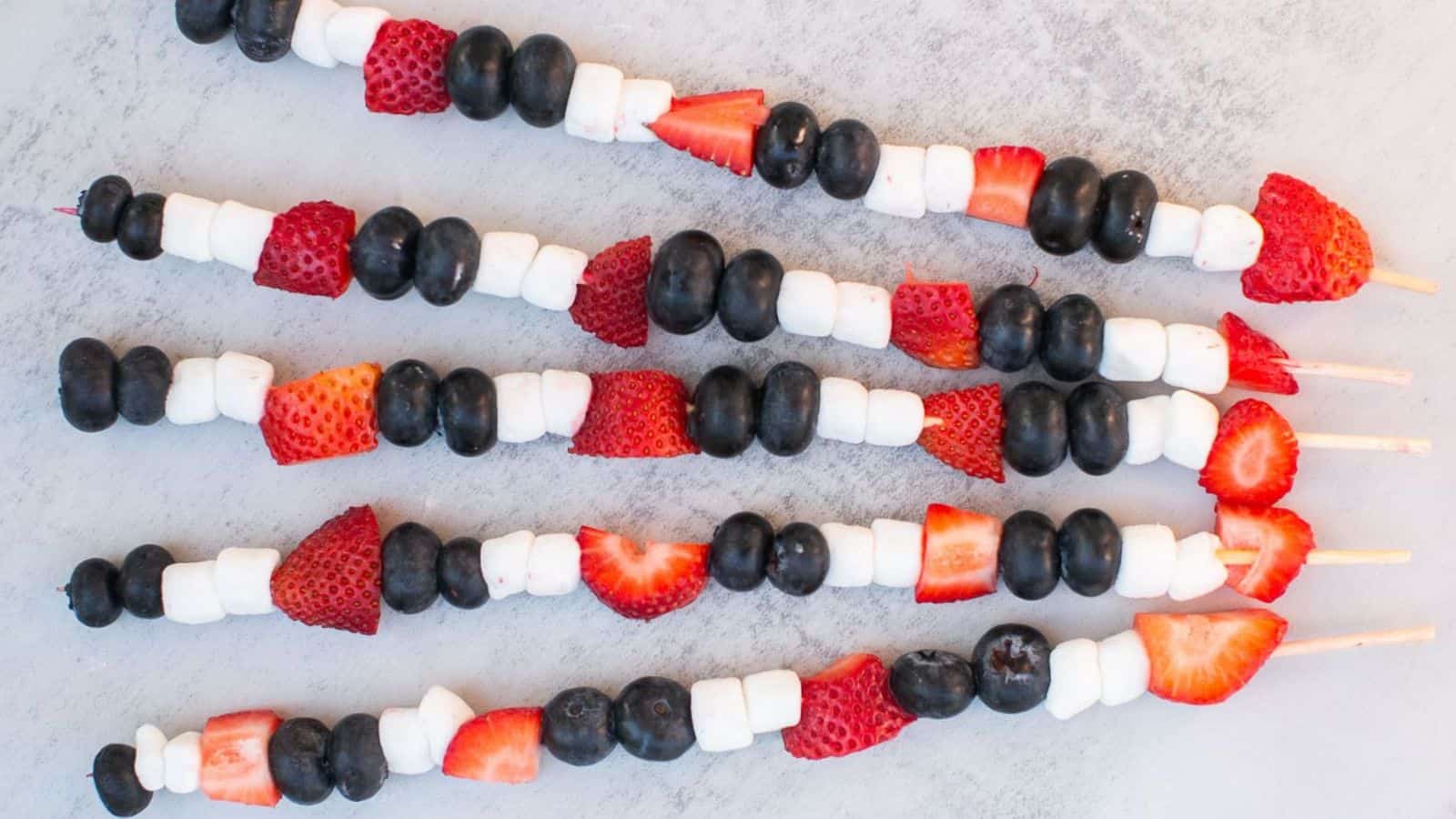 Fruit skewers layered with red, white, and blue fruit pieces for a festive treat.
