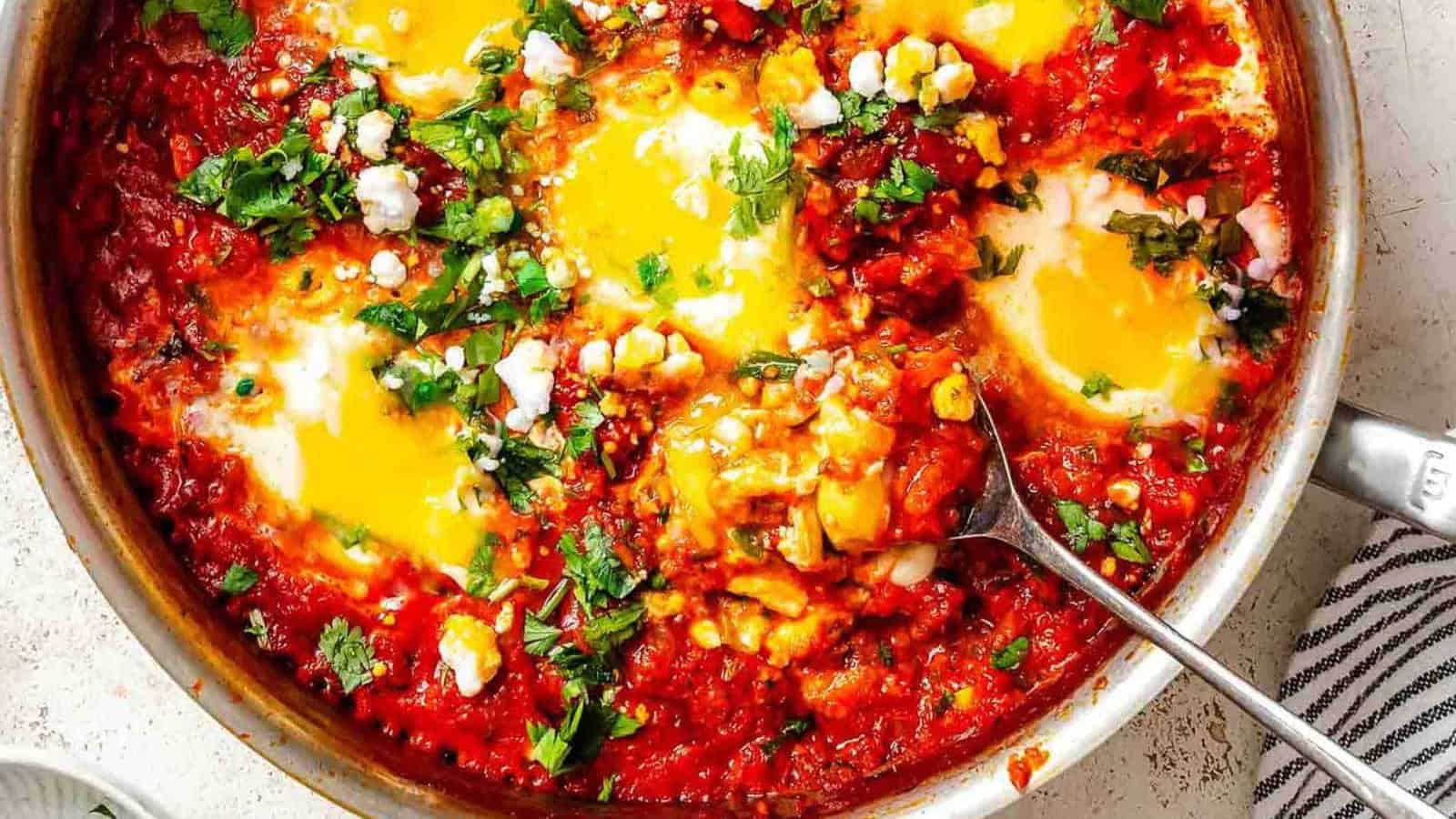 Eggs poached in spicy tomato sauce with herbs and vegetables.