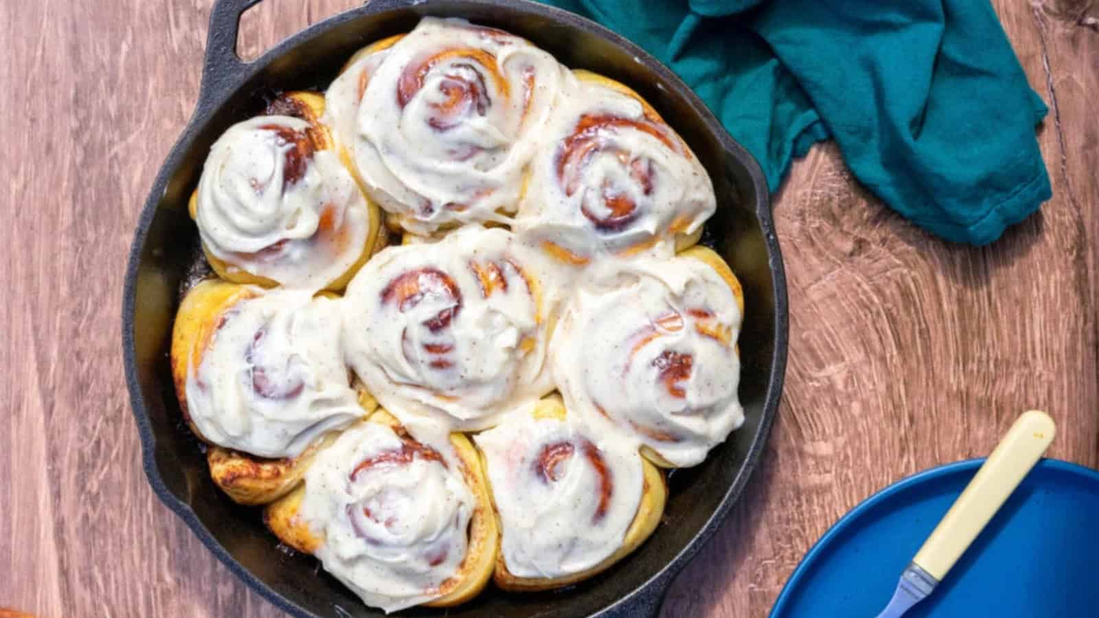 Sourdough cinnamon rolls topped with icing and soft spiraled layers.