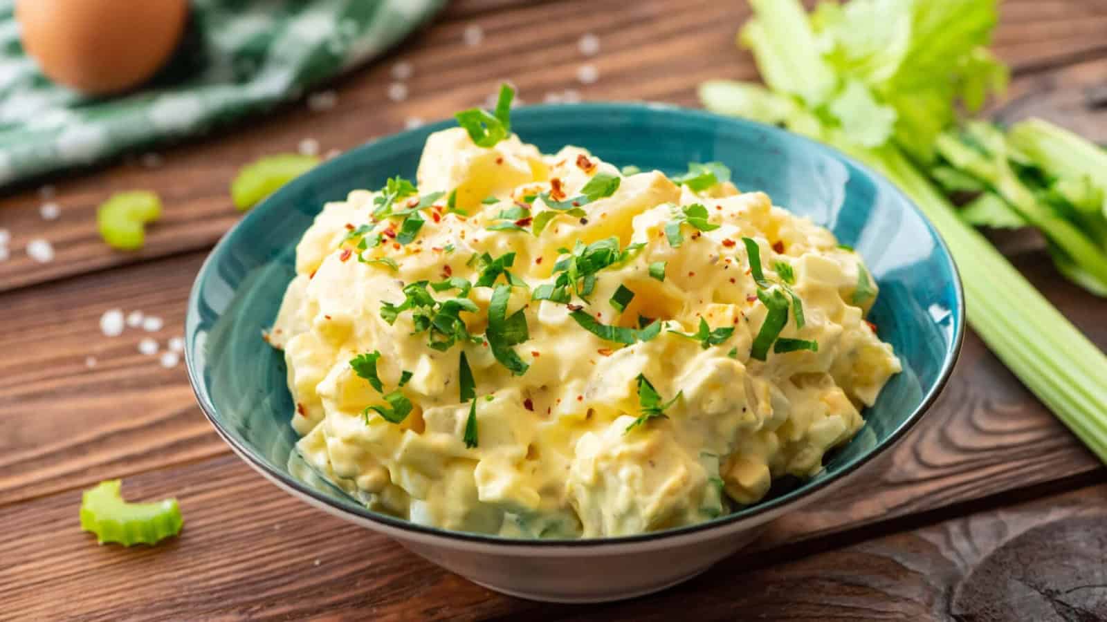 Creamy potato salad mixed with potatoes, herbs, and dressing.