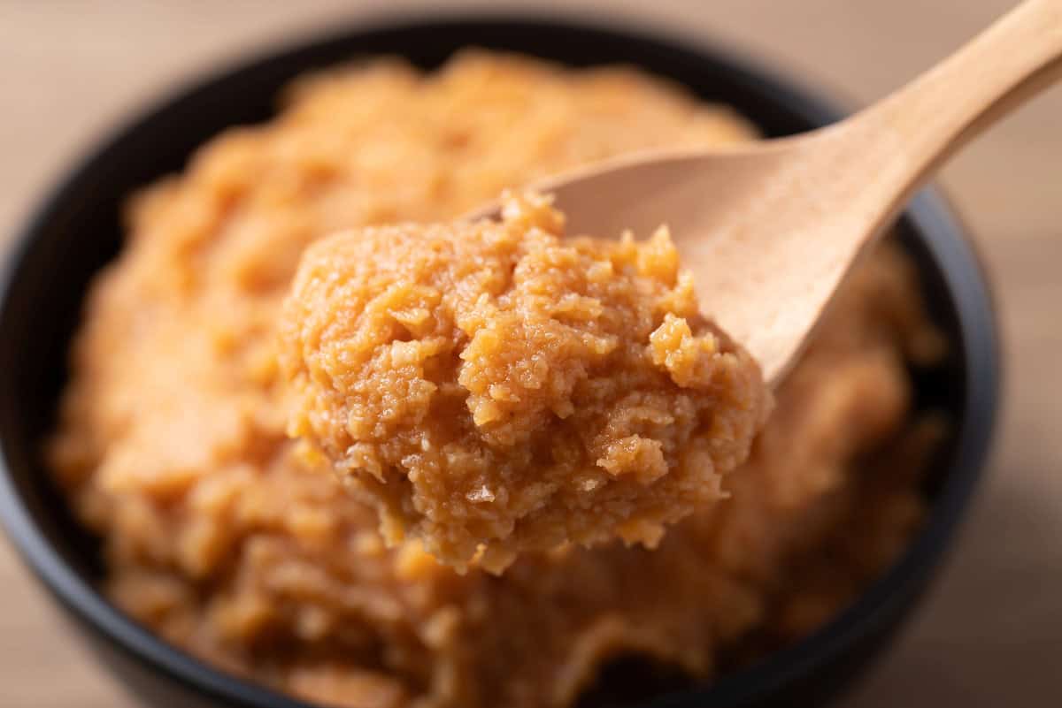 Close-up of a spoonful of miso paste showing its smooth, rich texture.