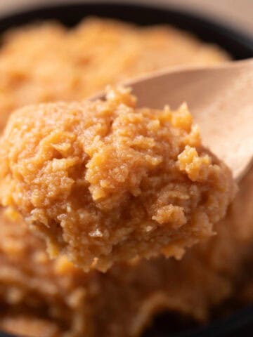 Close-up of a spoonful of miso paste showing its rich texture.