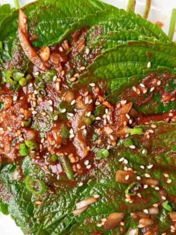 Flavorful Korean perilla leaf kimchi on a white plate.