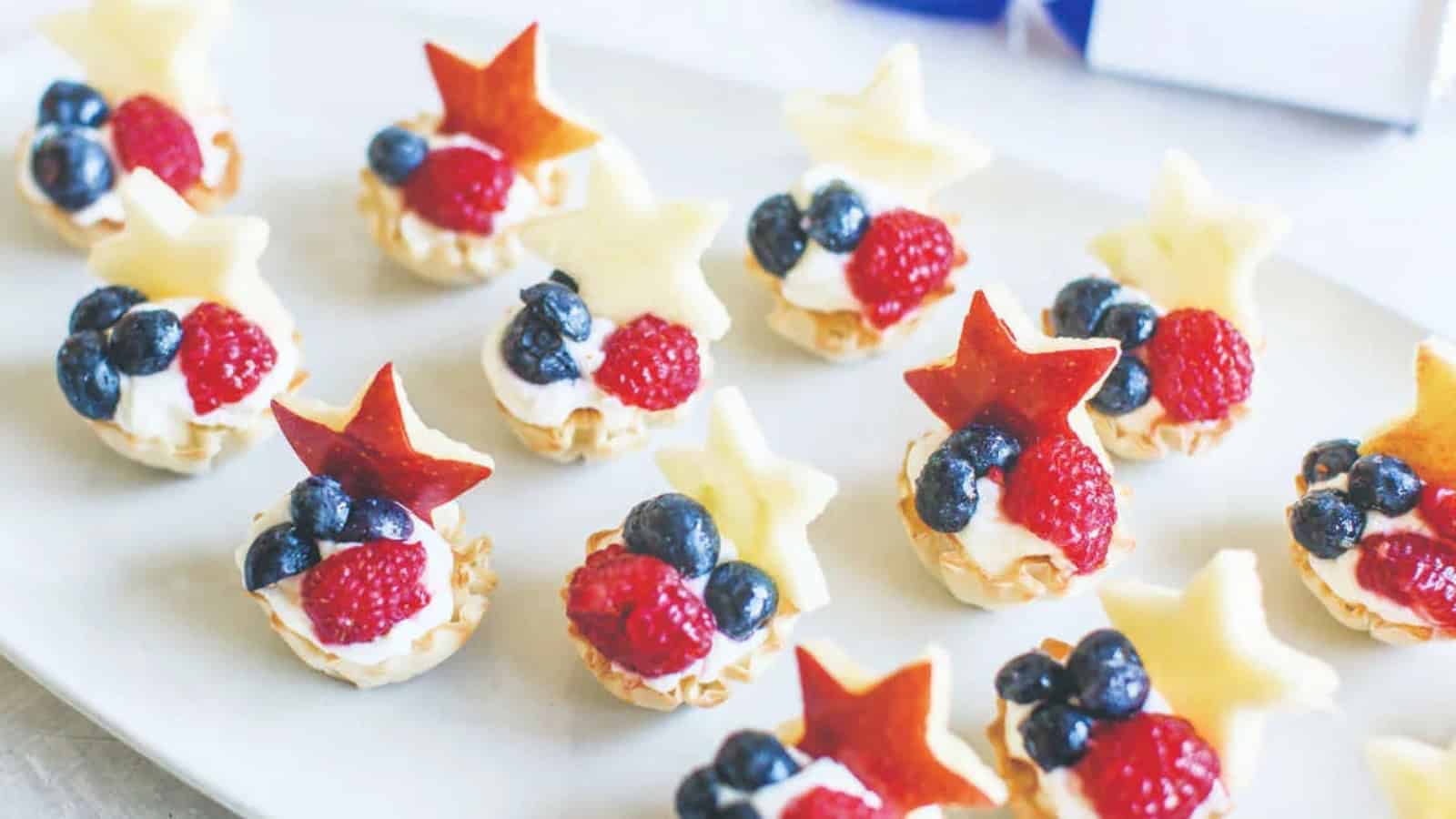 Mini cream cheese tarts topped with fresh fruit and a flaky crust.