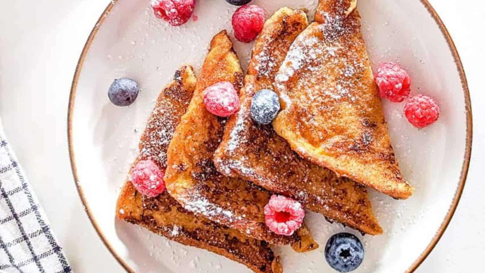 Golden German-style French toast served with powdered sugar and toppings.