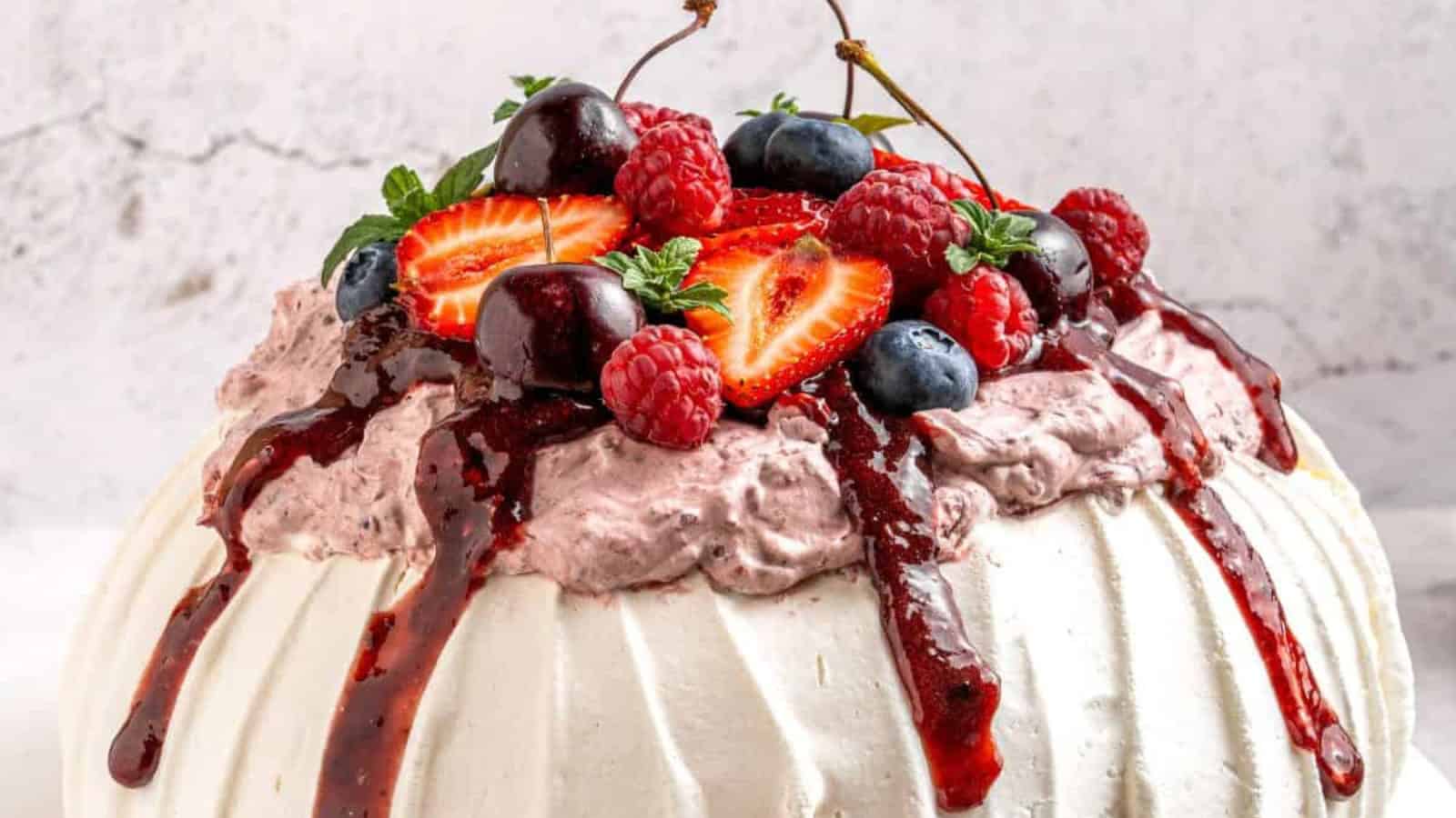 Berry pavlova topped with whipped cream and an assortment of fresh berries.