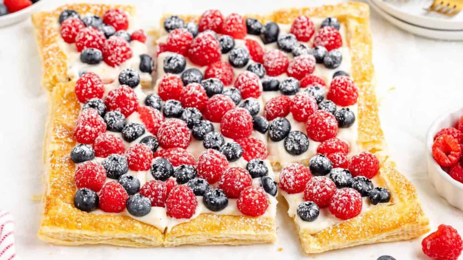 Puff pastry tart topped with cream and fresh mixed berries.