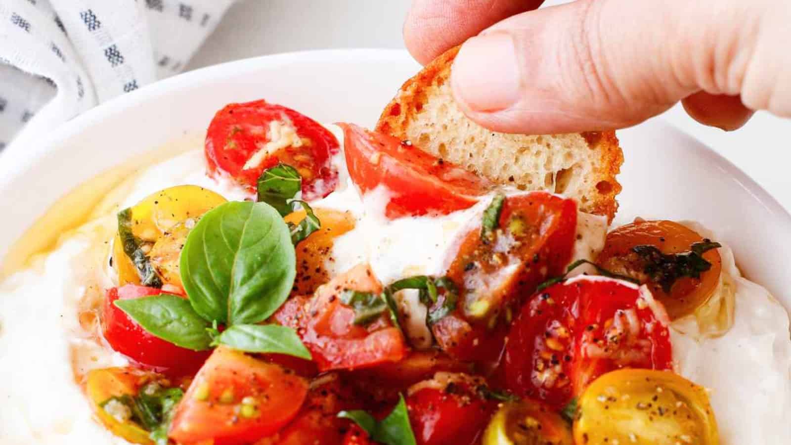 Bruschetta dip topped with diced tomatoes, herbs, and cheese.