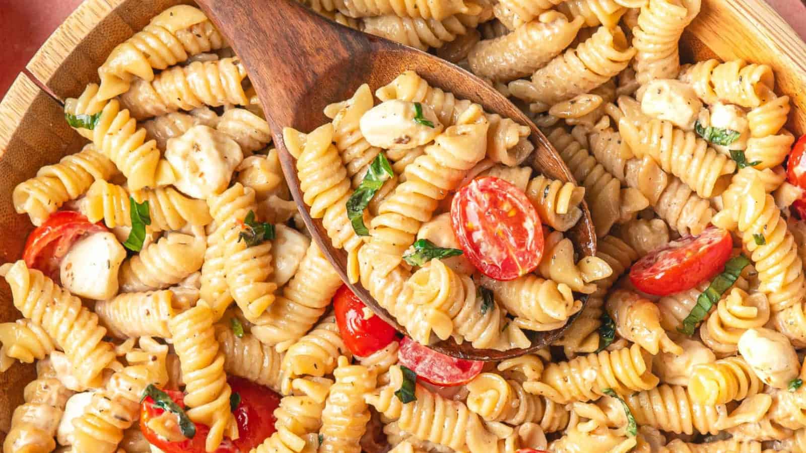 Pasta salad with tomatoes, mozzarella, basil, and a light dressing.