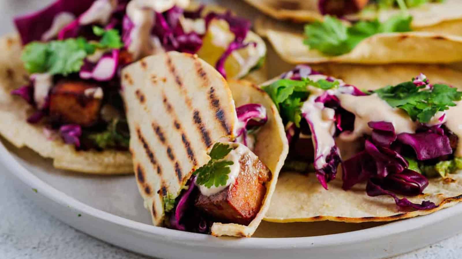 Tacos filled with spicy tofu and fresh vegetable toppings.