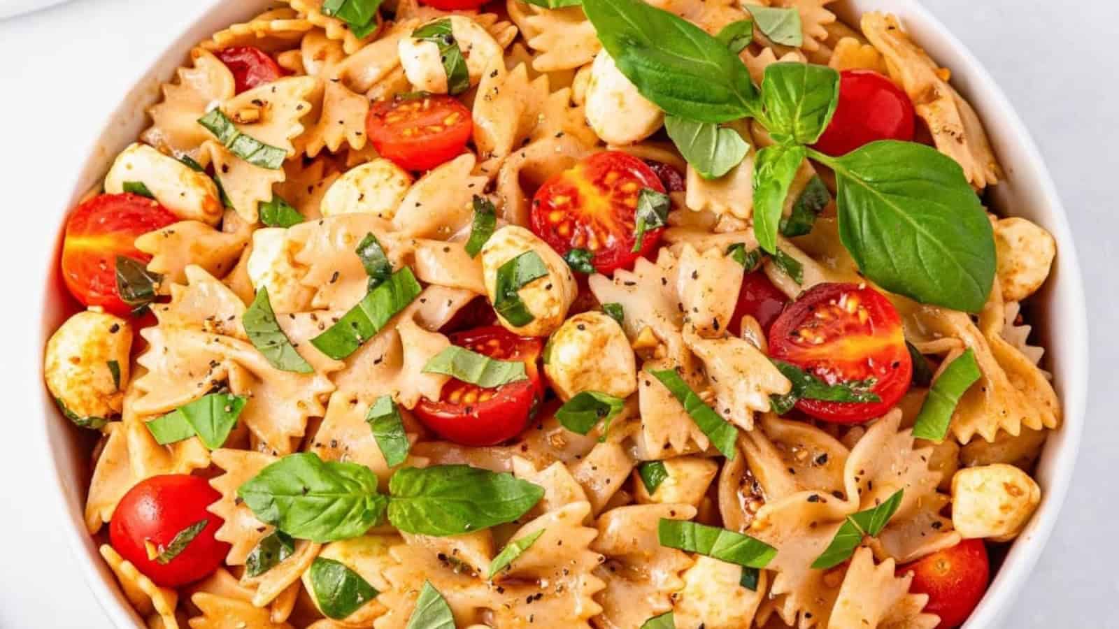 Caprese pasta salad with tomatoes, mozzarella, basil, and pasta.