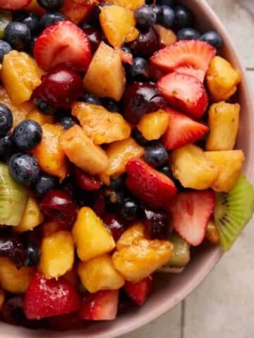 Mixed fruit salad with honey lime dressing in a bowl.