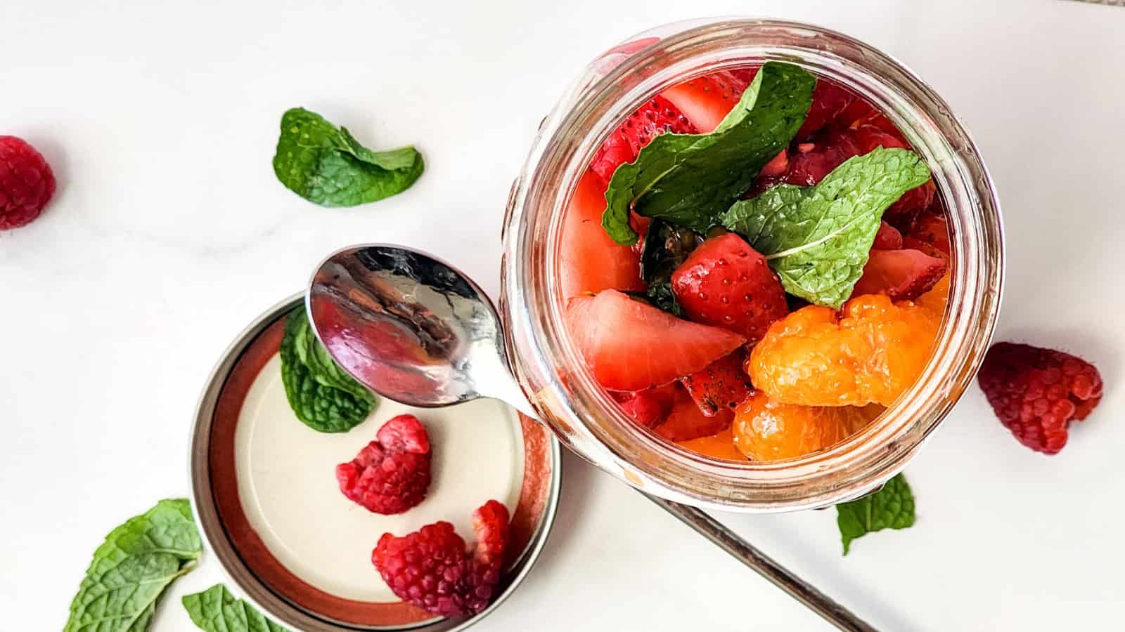 Mason jar berry fruit salad layered with fresh strawberries, blueberries, and raspberries.