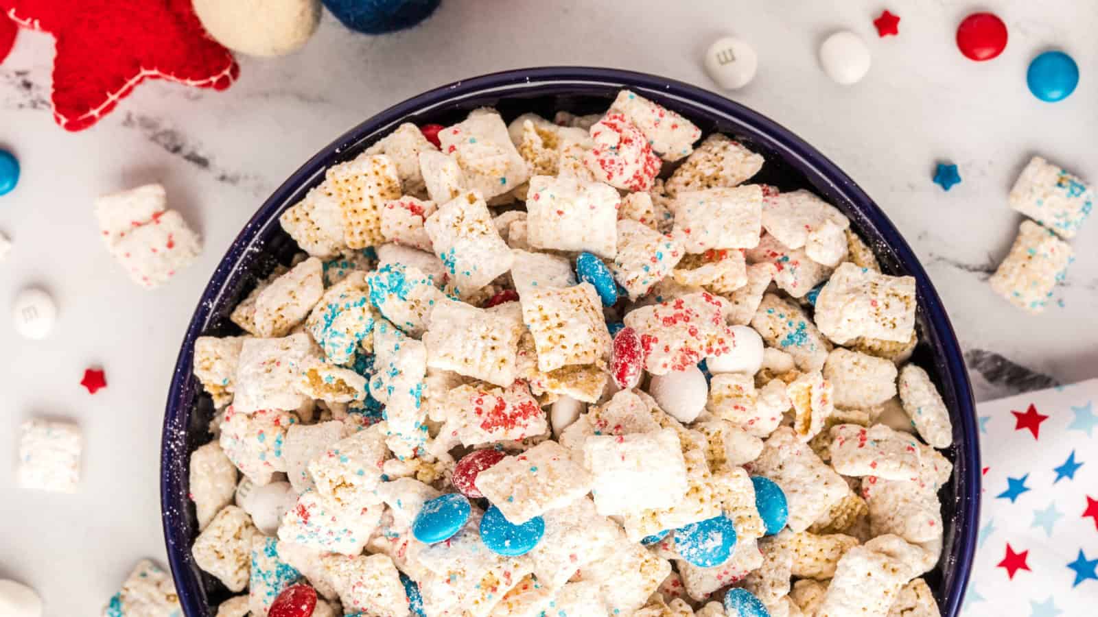 Puppy chow coated in white chocolate and dusted with powdered sugar.