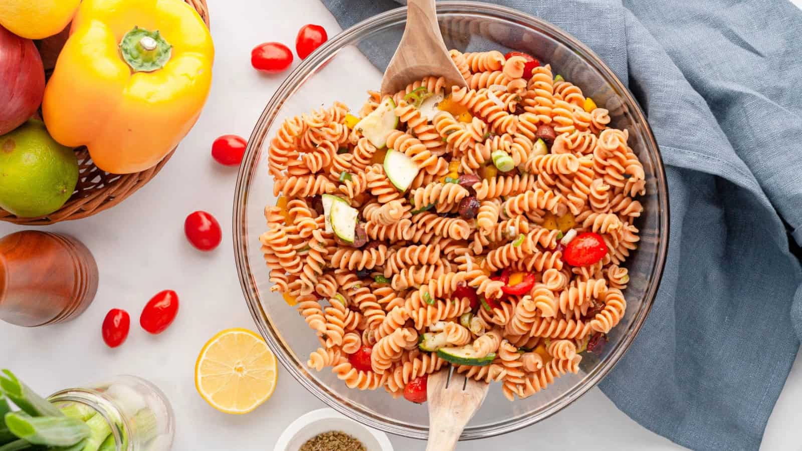 Red lentil pasta salad tossed with vegetables and a flavorful dressing.