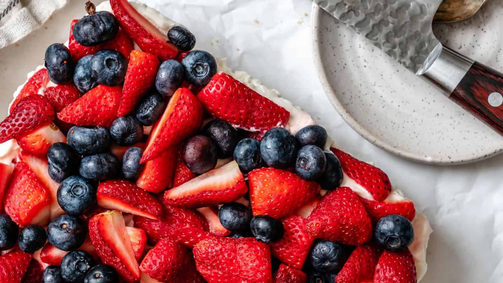 Red, white, and blue pretzel salad layered with creamy filling and fresh berries.
