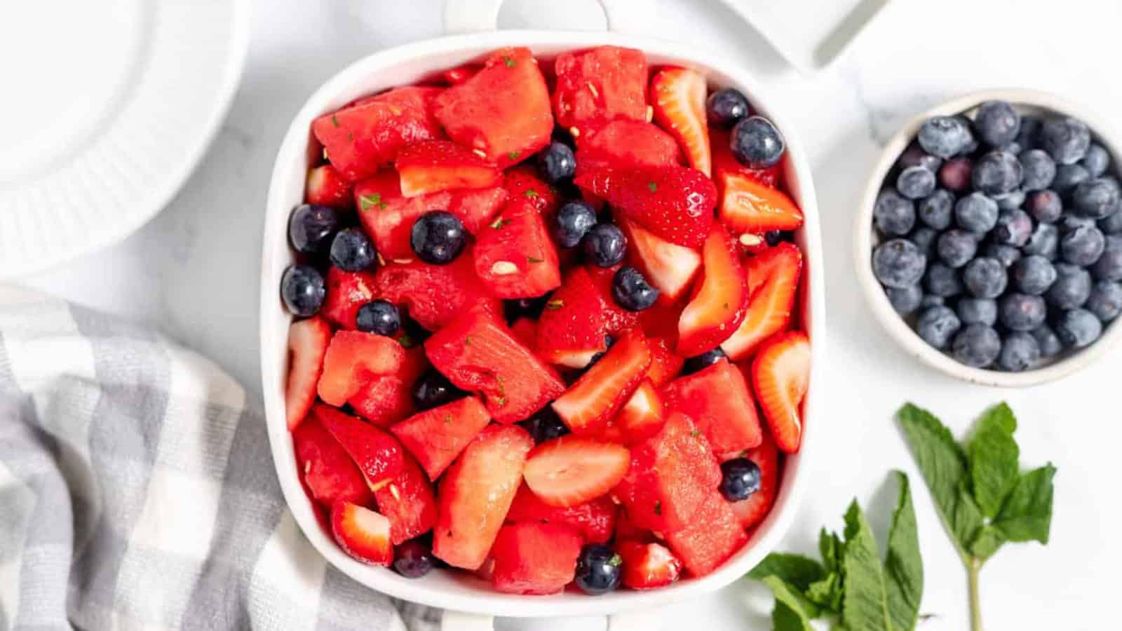 Festive fruit salad made with strawberries, blueberries, and mini marshmallows.