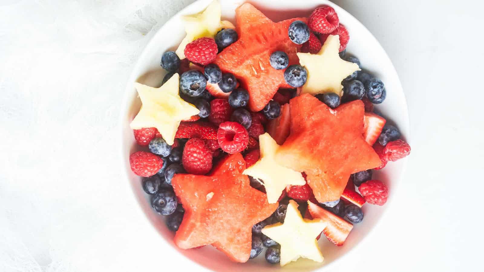 Patriotic fruit salad made with strawberries, blueberries, and light dressing.