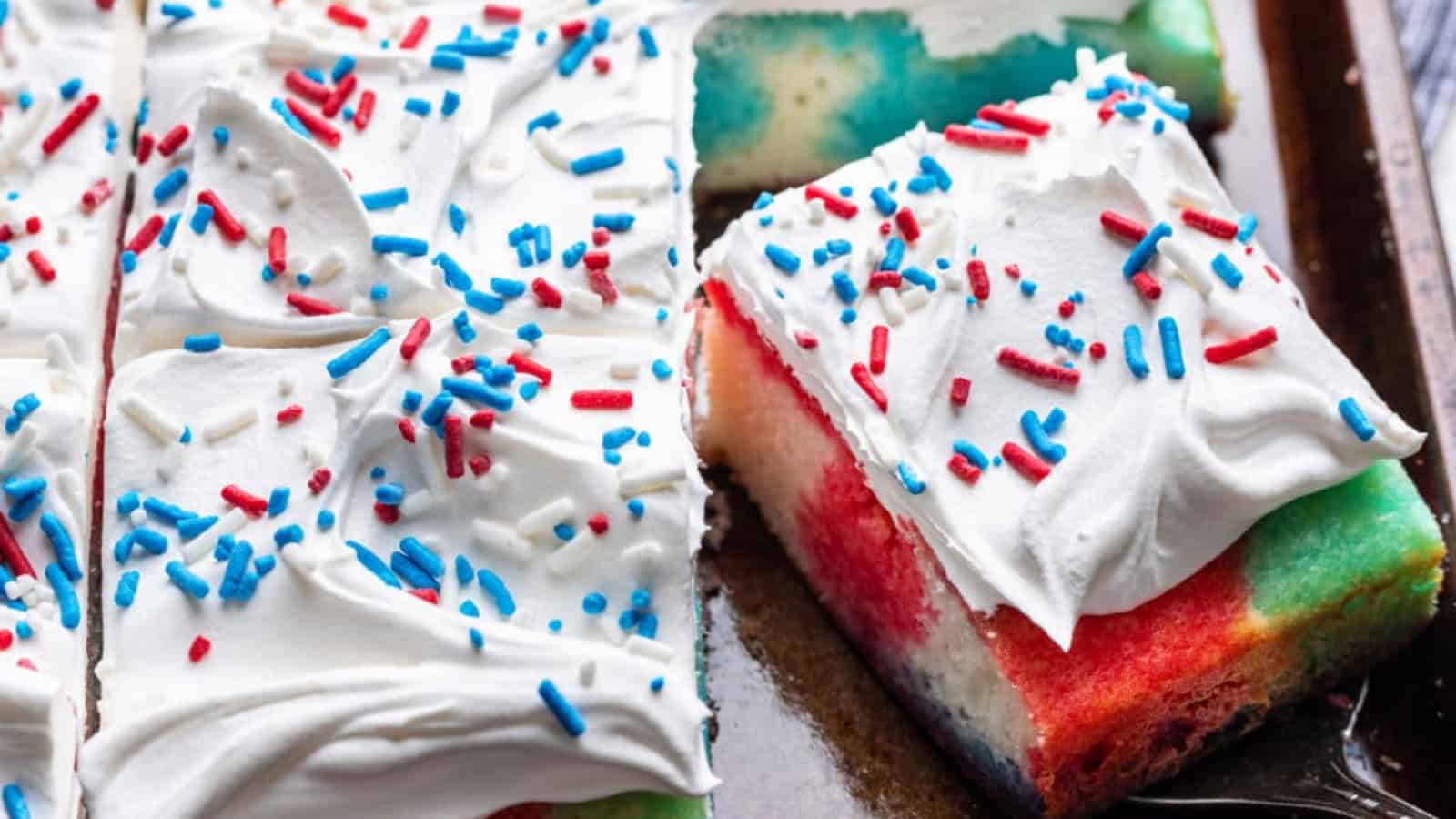 Patriotic poke cake topped with whipped cream and fresh berries.