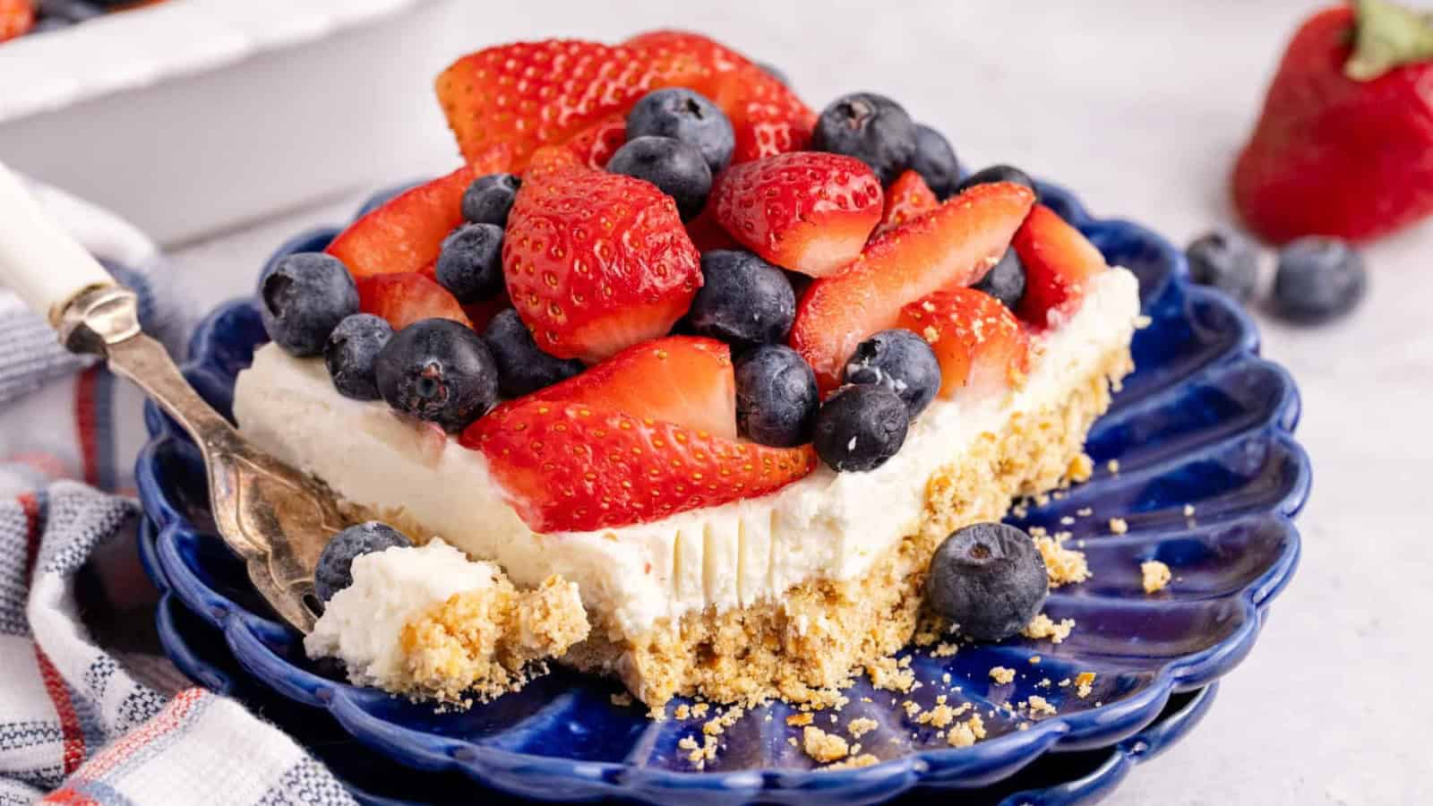 Layered pretzel salad topped with creamy filling and fresh berries.