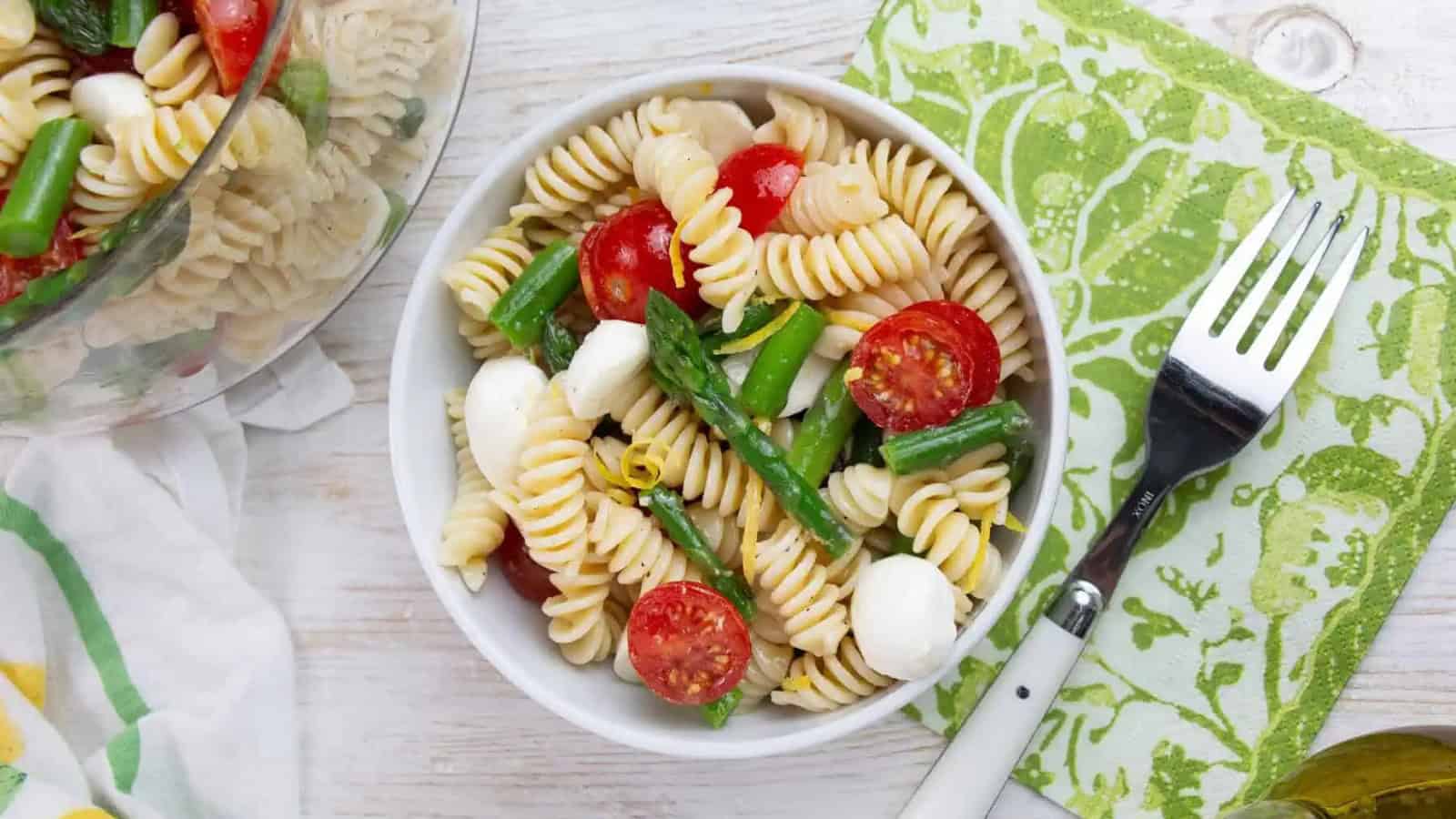 Spring pasta salad with asparagus, tomatoes, and fresh vegetables.