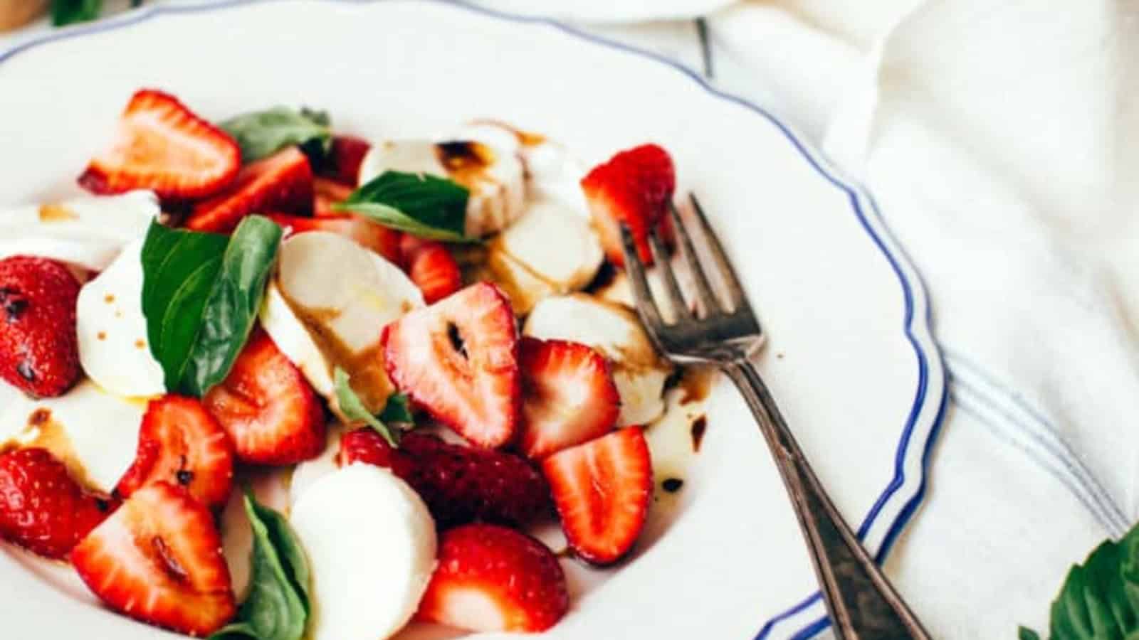 Strawberry Caprese salad with mozzarella, basil, and a drizzle of balsamic glaze.